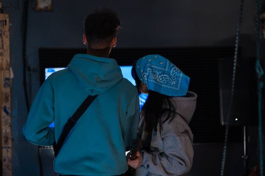 A man and woman together indoors, focused on gaming. Captured in a cozy setting.