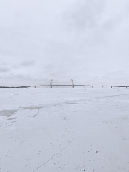 Snow Covered Field Under Cloudy Sky