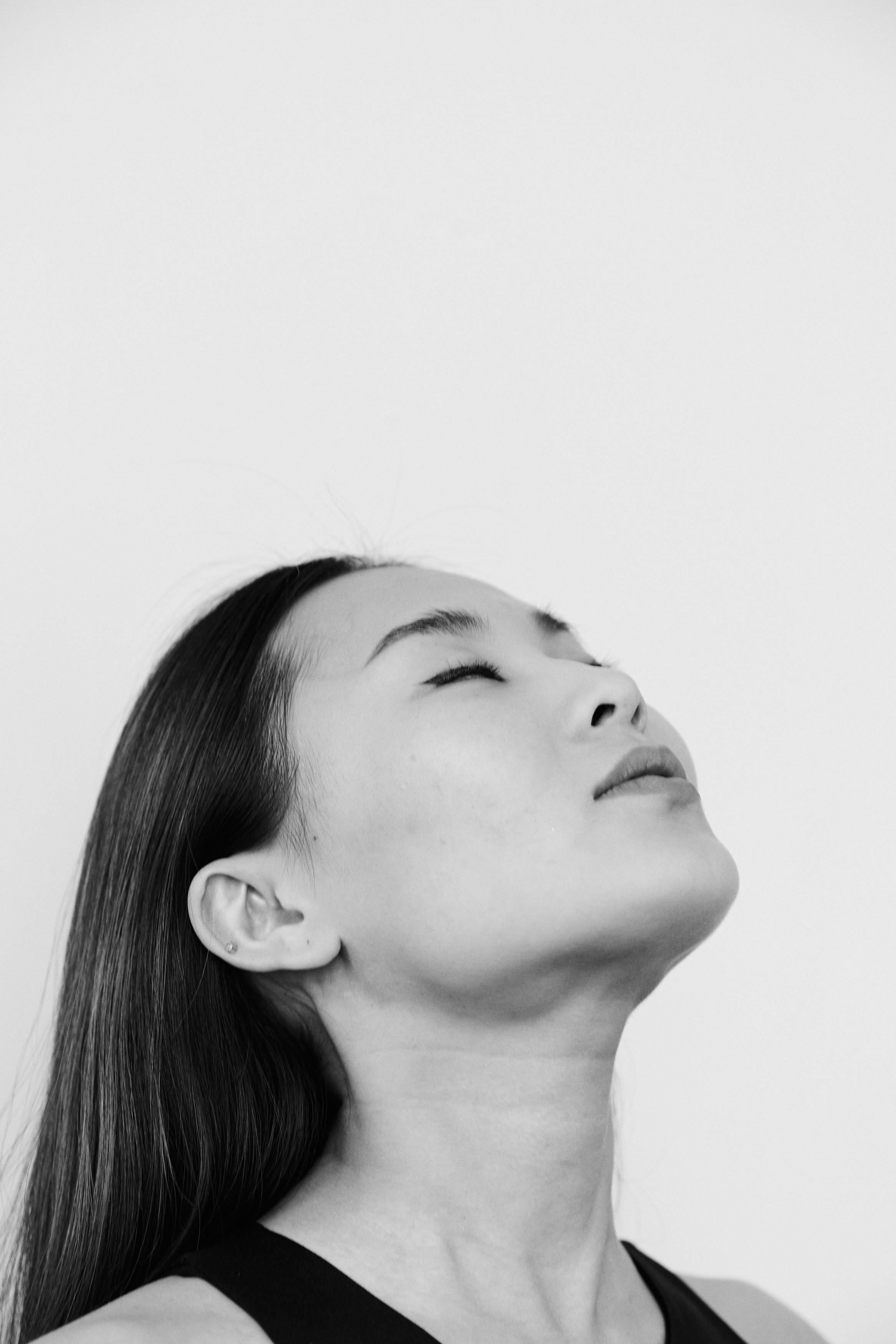 Serene woman side profile eyes closed in black and white, blissful expression during intimate surrender