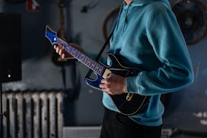 Man in Blue Long Sleeve Shirt Playing Guitar Hero