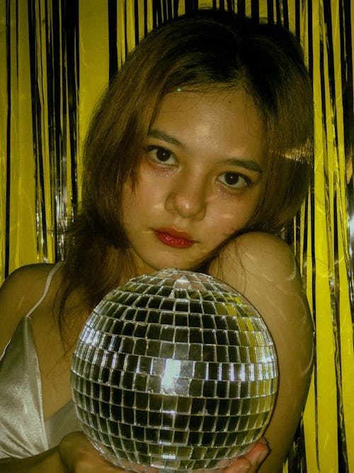 Free Pretty Woman Holding a Disco Ball Stock Photo
