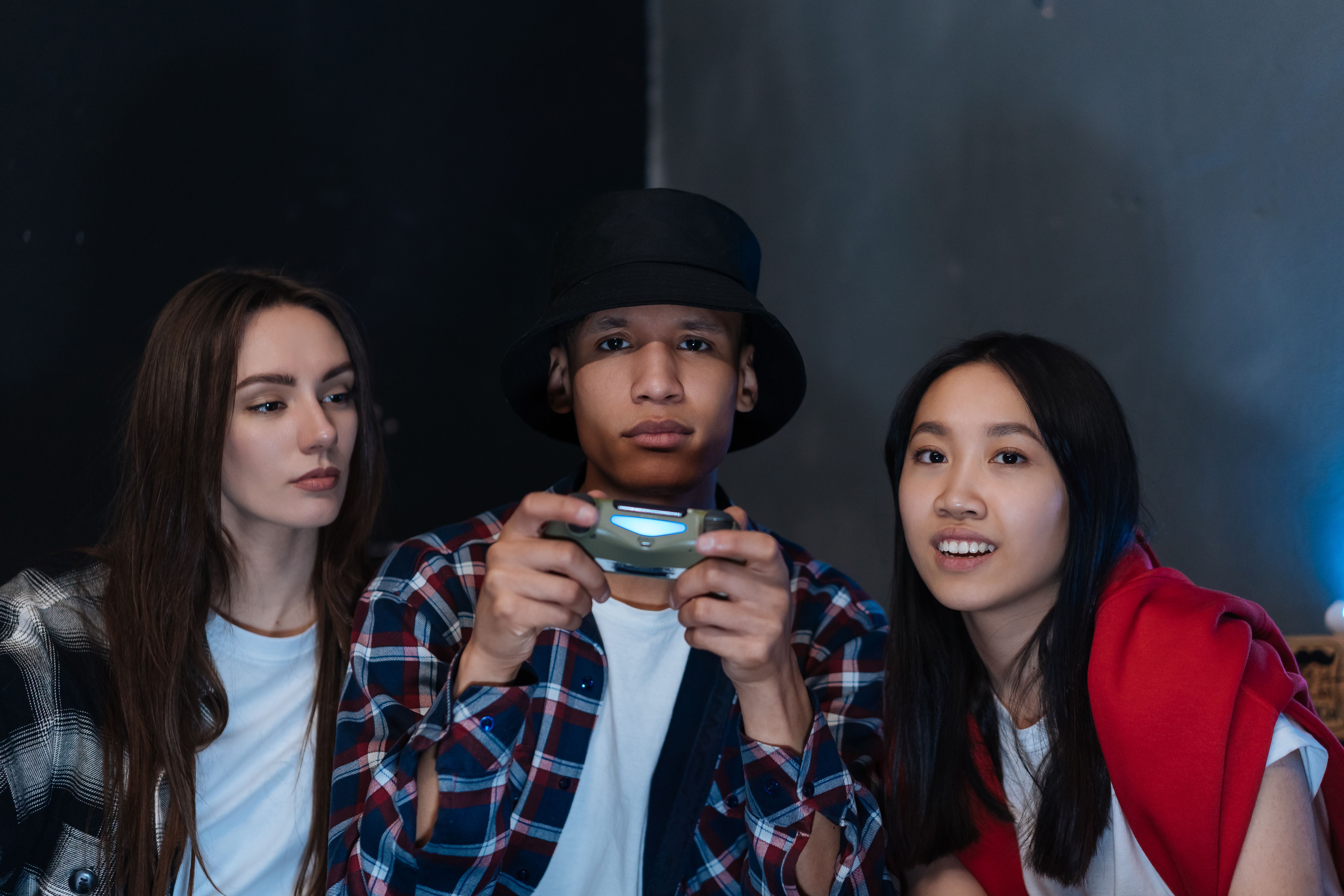 Three friends enjoying a gaming session, sharing fun and leisure indoors.