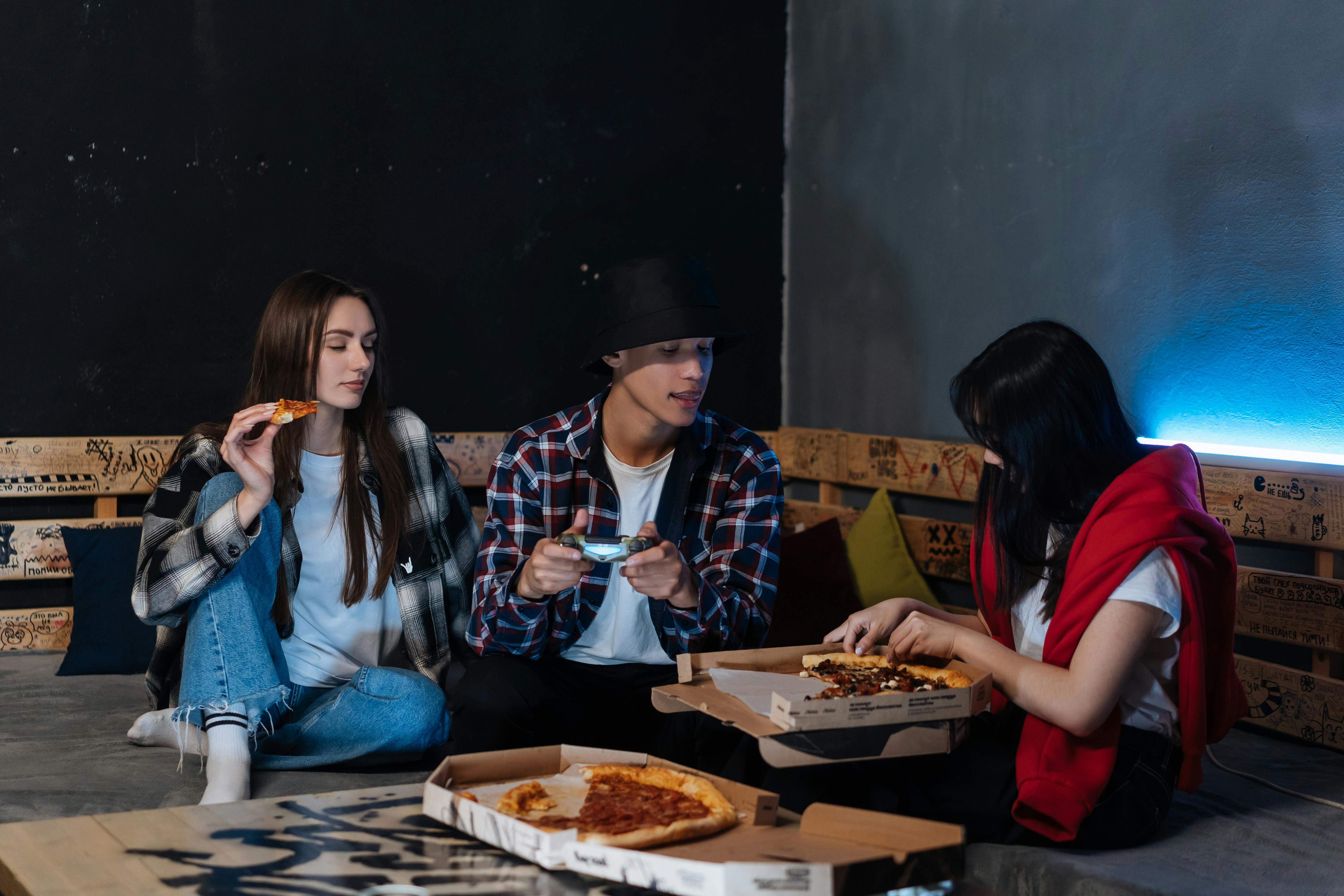 Happy Friends hanging out Together and eating Pizza · Free Stock Photo