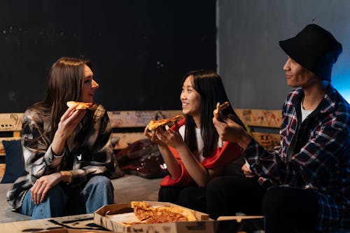 Happy Friends hanging out Together and eating Pizza 