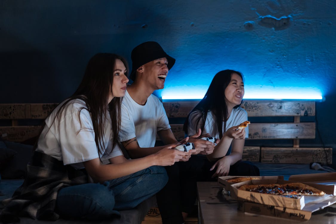 Jovens jogando videogame e comendo Pizza. 