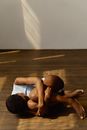 Woman in White Swimsuit Lying Down on Wood Flooring