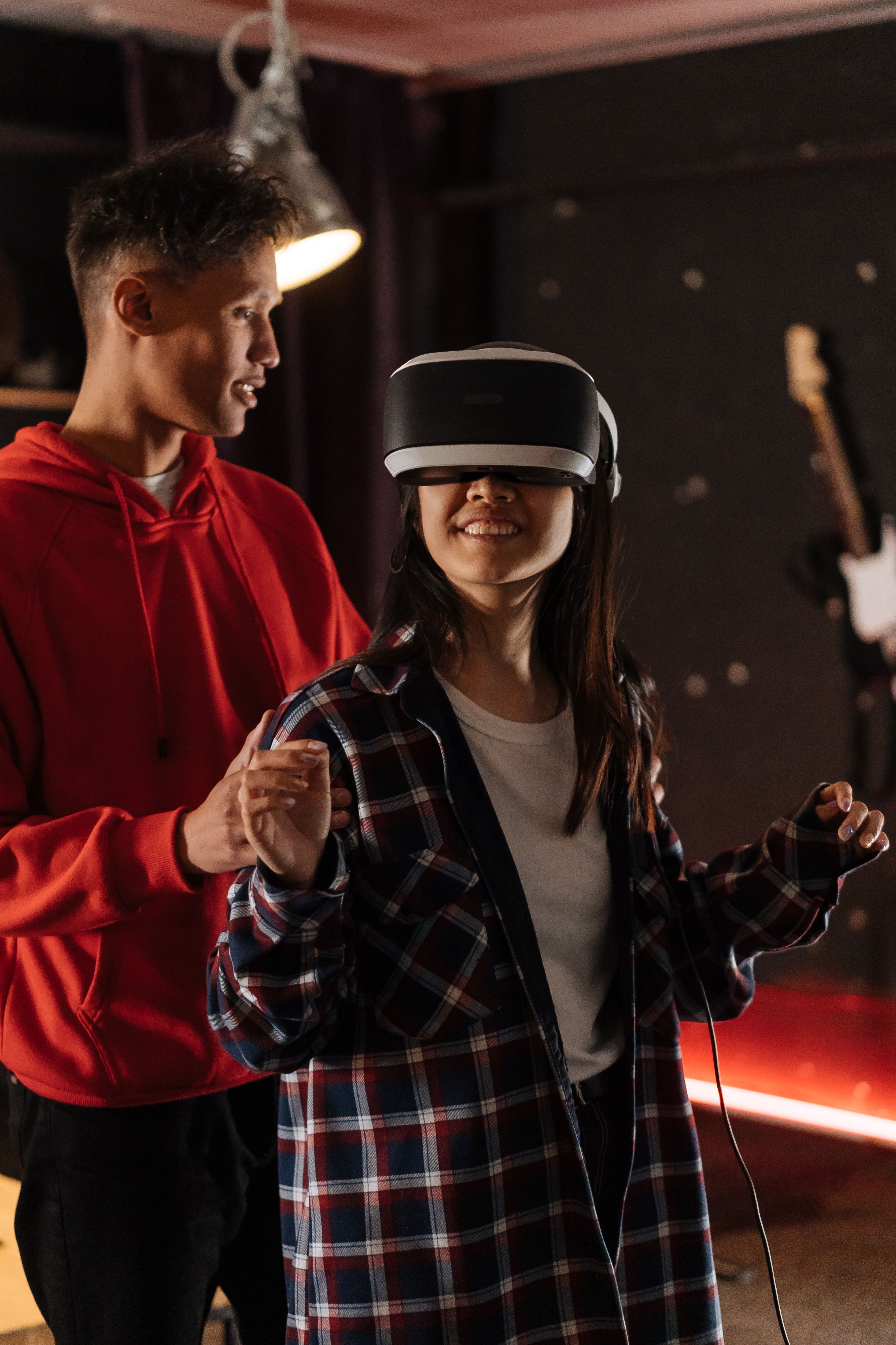 Free Two young adults exploring virtual reality gaming in an indoor setting. Stock Photo