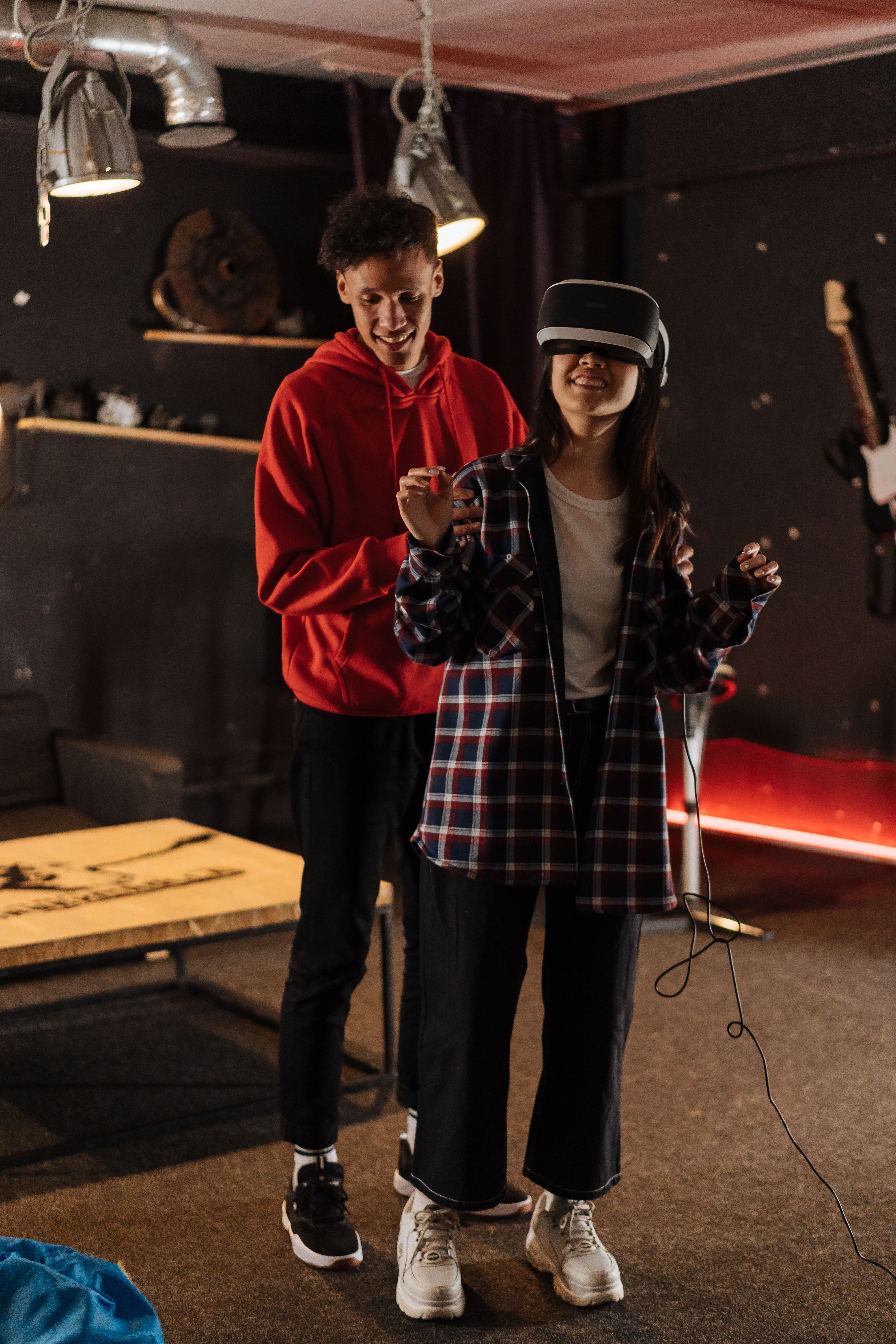 Free Young adults using VR technology indoors, experiencing immersive virtual reality together. Stock Photo