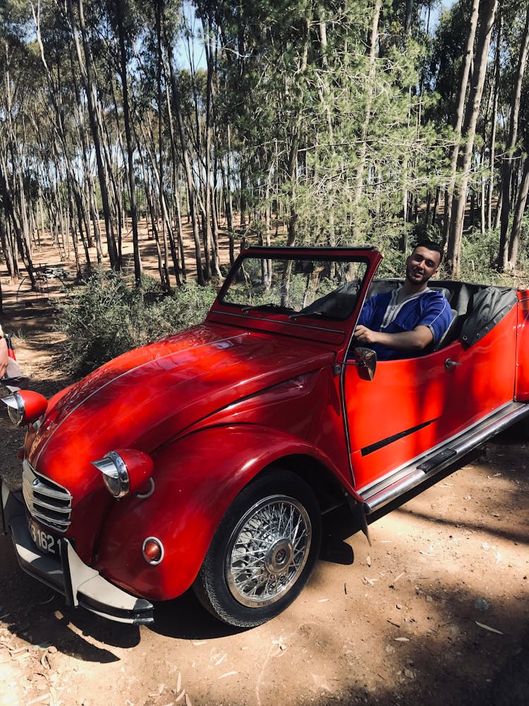 Man Driving A Red Convertible Car