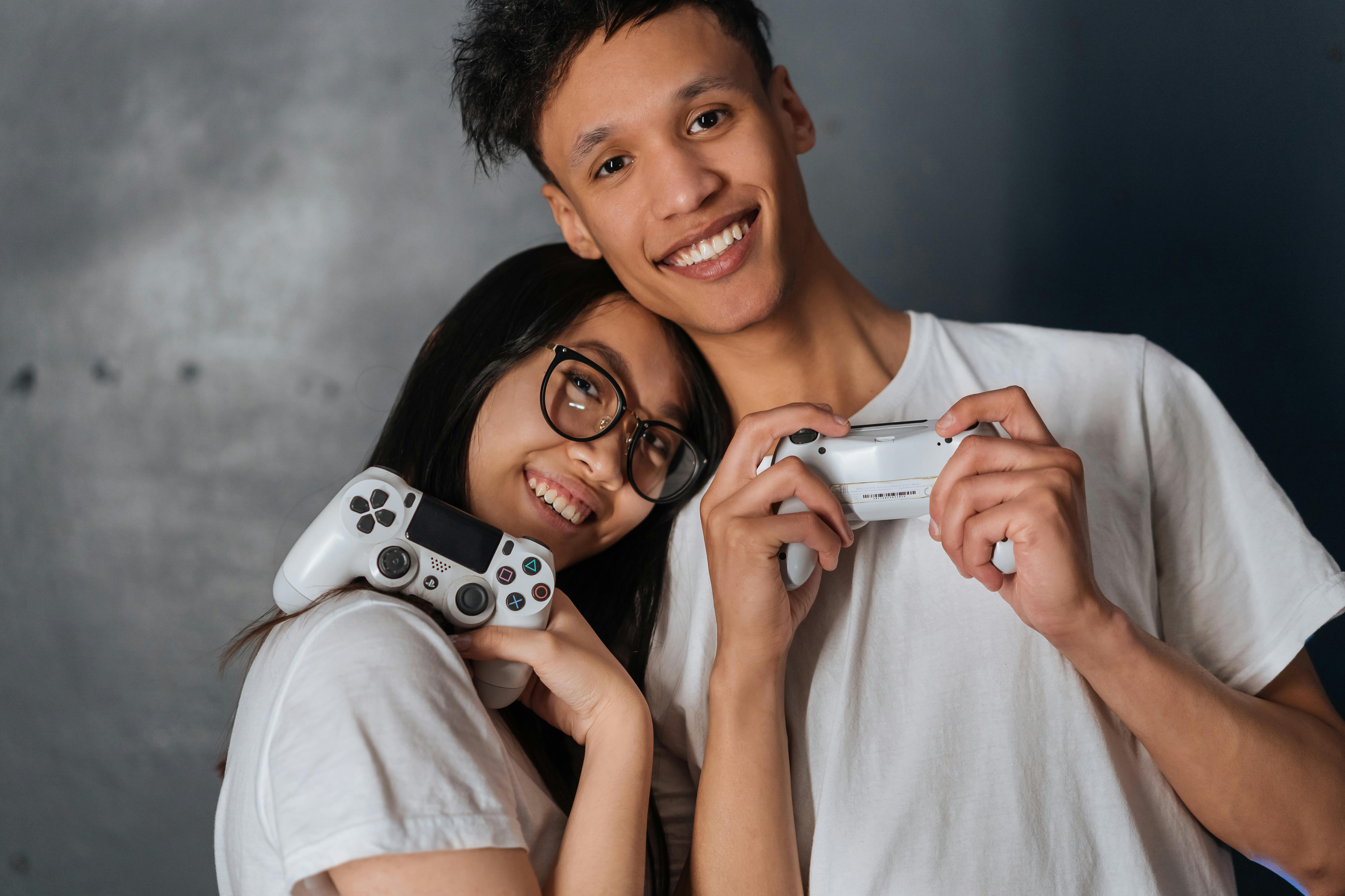 Cheerful boyfriend and girlfriend playing video games to win. Happy couple  using controller to play online game and winning gameplay on console.  People holding joystick to have fun Stock Photo - Alamy