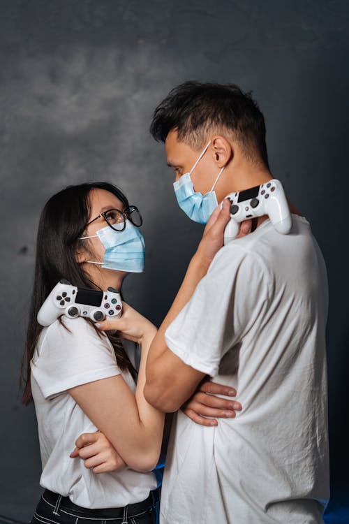 Man and Woman Holding Game Controllers