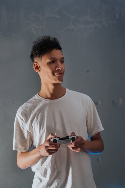 Man in White Shirt holding a Gaming Console 