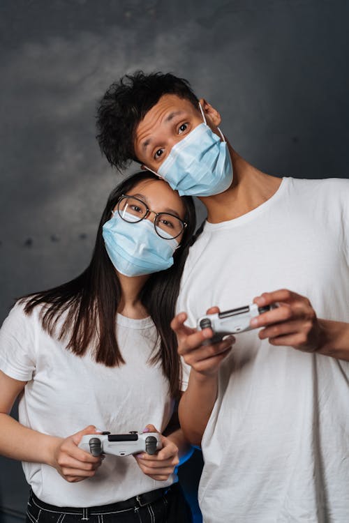 Man and Woman Holding Game Controllers