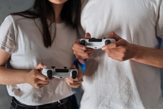 Close-up of a couple holding game controllers, enjoying a gaming session indoors.