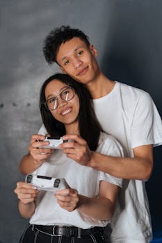 Smiling young couple holding game controllers enjoying gaming together.