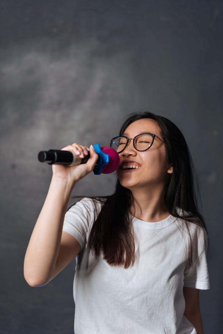 Young Woman Holding A Microphone And Singing