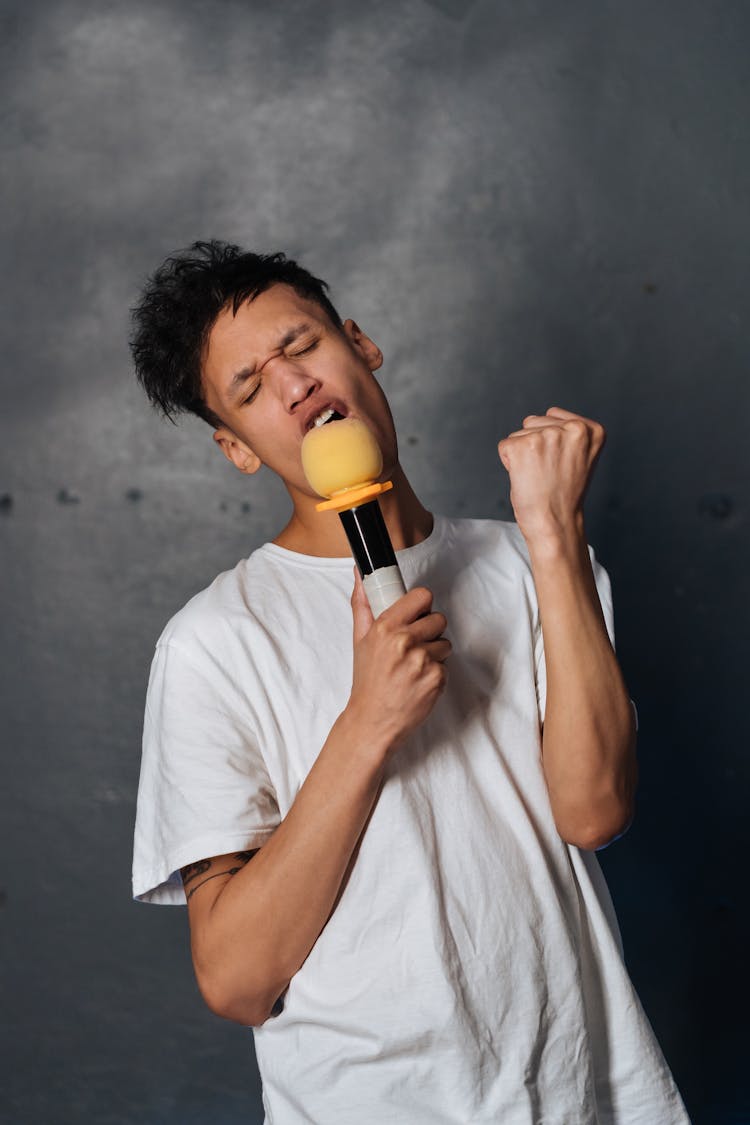 Young Man Singing In A Microphone 