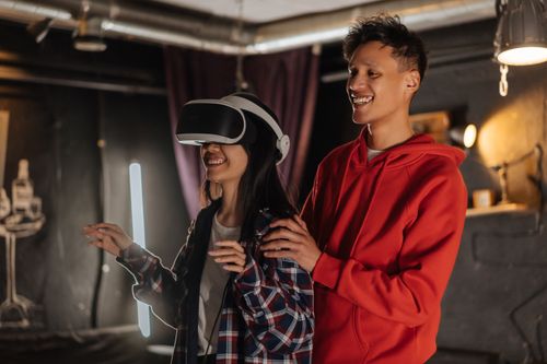 Free Young couple playing and enjoying VR headset indoors with smiles and joy Stock Photo