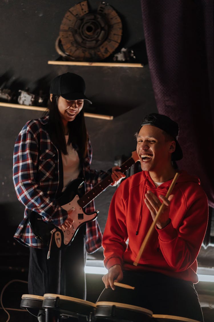 A Man And Woman Playing Guitar And Drums