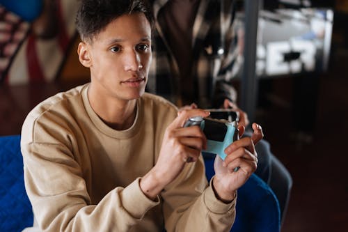 Man Wearing a Beige Sweater Playing a Video Game