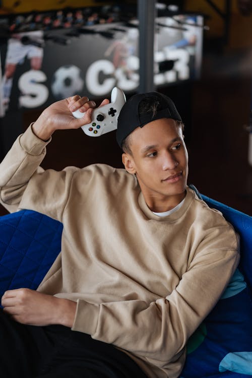Man in Brown Sweater Holding a Game Controller