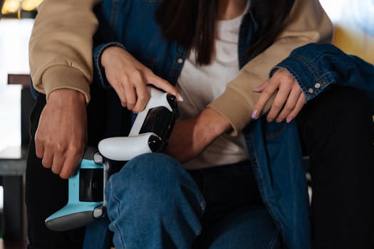 A couple dressed in denim jackets playing video games with wireless controllers.