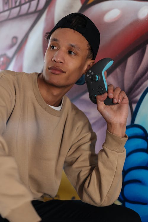 A Man in Brown Sweater Holding Black and Blue game Controller