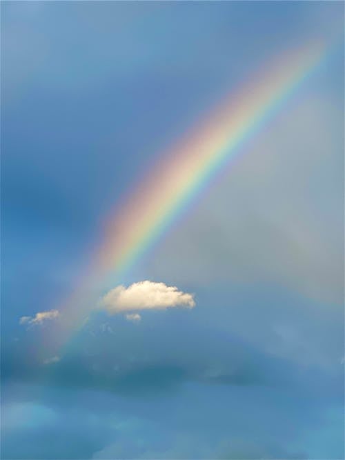 Rainbow and White Clouds On Blue Sky