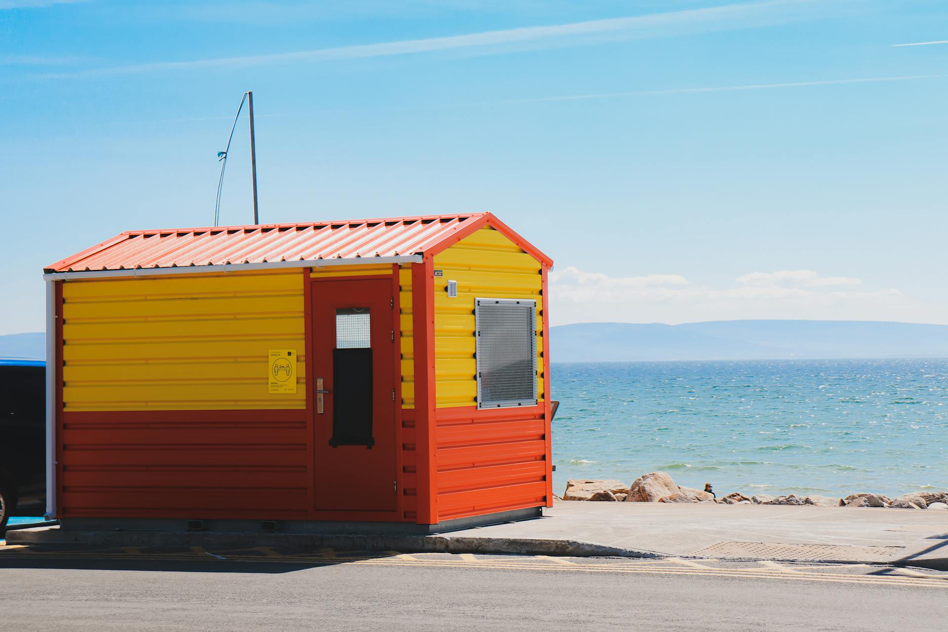 Colorful yellow and red beach hut by the seaside at Galway Bay, Ireland.