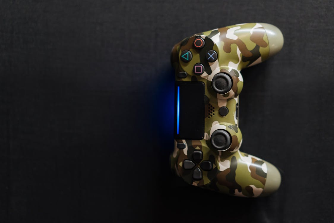 A Camouflage Game Controller on Black Surface