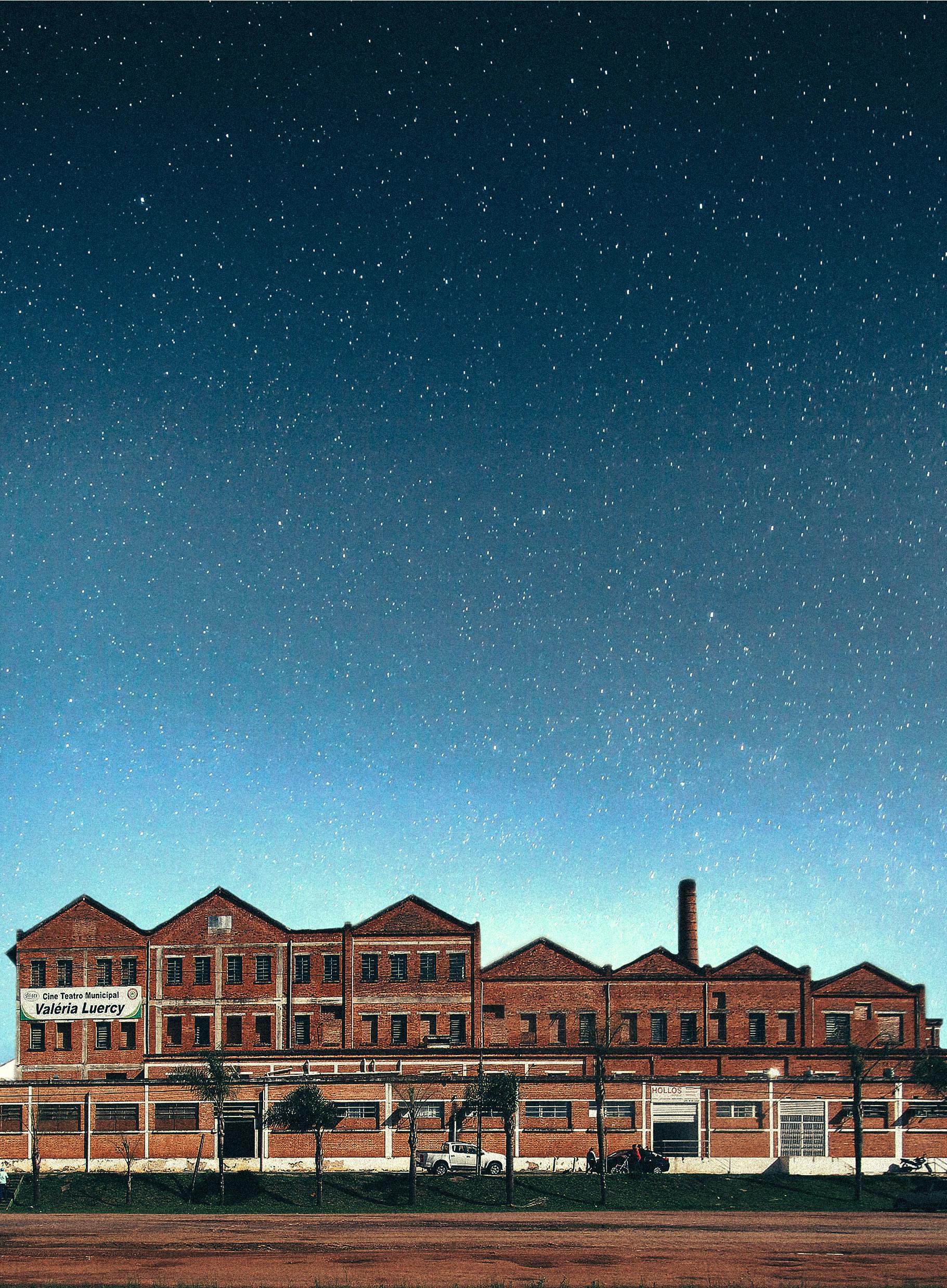 在星光灿烂的夜空下，一座老式砖砌工厂建筑闪闪发光，展现了工业建筑的风貌