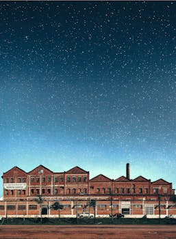 在星光灿烂的夜空下，一座老式砖砌工厂建筑闪闪发光，展现了工业建筑的风貌