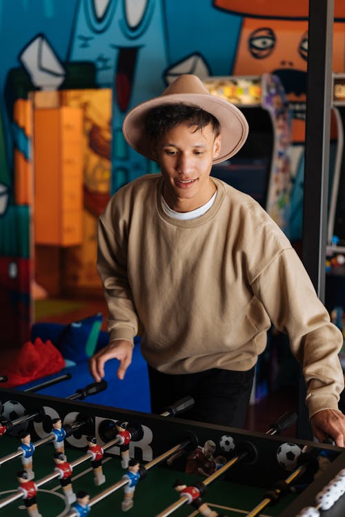 Man Playing A Football Arcade Machine