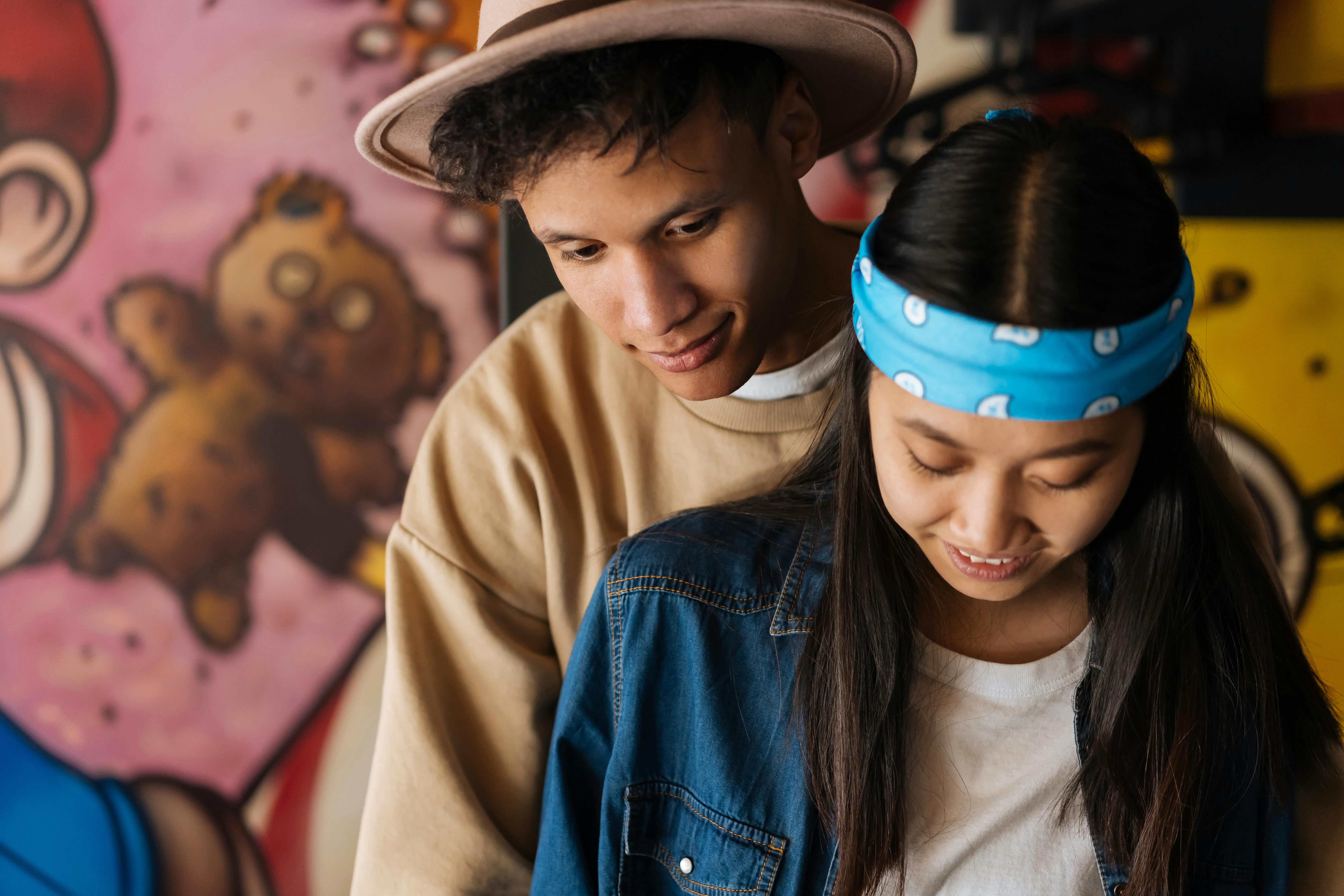 a girl with a blue headband beside a man with a hat