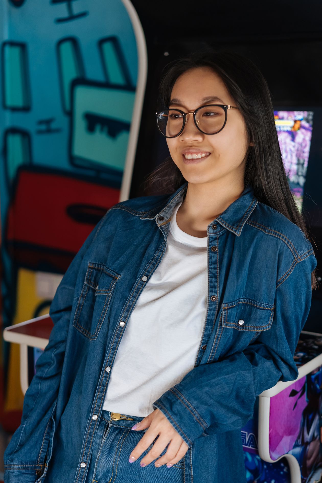 Smiling woman in a plain white crew-neck tee layered under a denim shirt