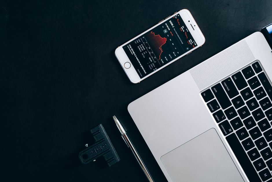 Modern workstation setup showcasing laptop, smartphone, and financial data for business use.
