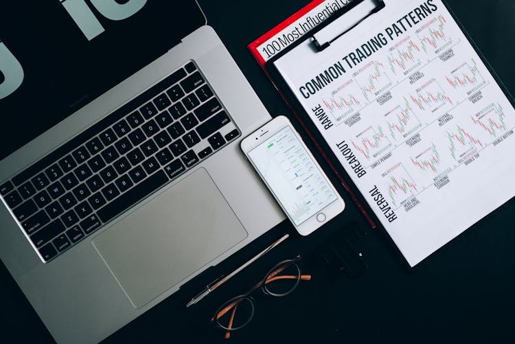 Smartphone, Laptop And Paper Printout On Flat Surface