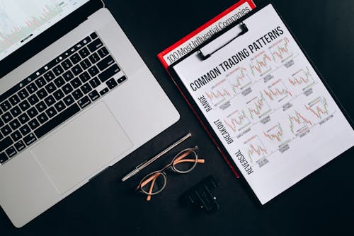 Printout Graphs on a Clipboard Beside a Laptop