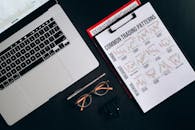 Printout Graphs on a Clipboard Beside a Laptop