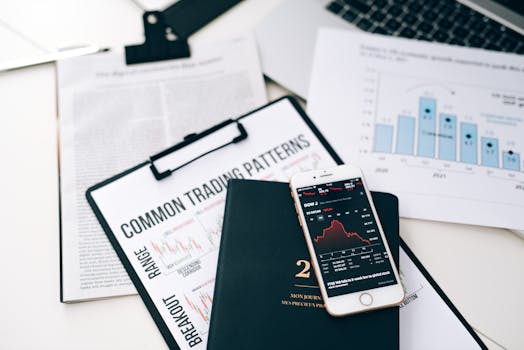 Overhead view of financial graphs and smartphone displaying stock market trends on a desk.