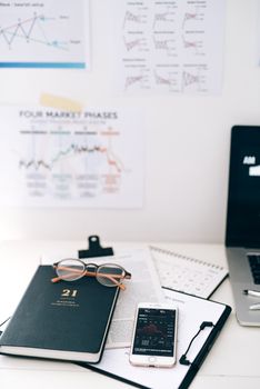 A workspace with smartphone and financial graphs, ideal for business concepts.