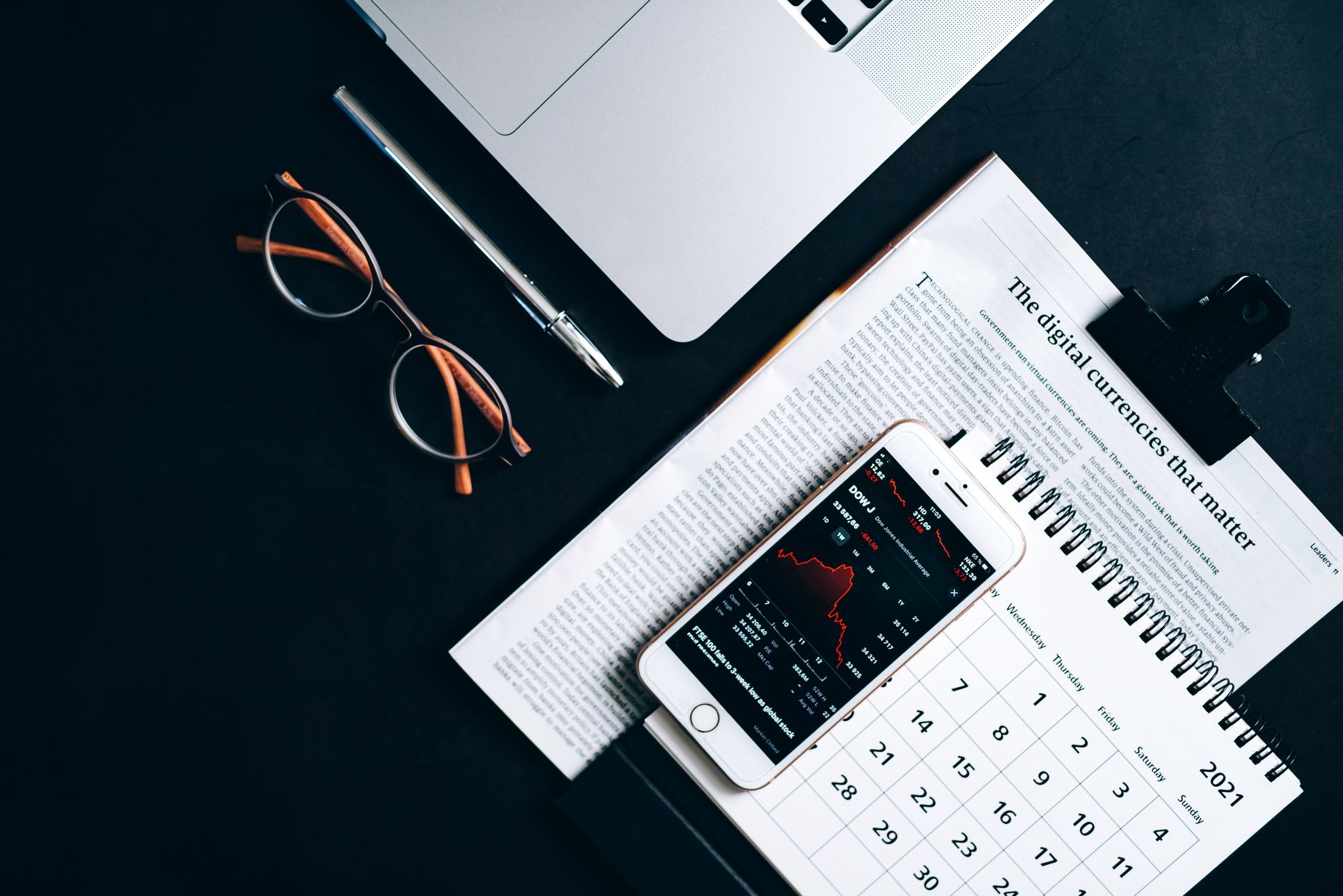 Flat lay of electronic devices and financial documents showcasing digital currency analysis.