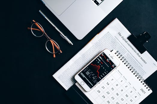 Flat lay of electronic devices and financial documents showcasing digital currency analysis.