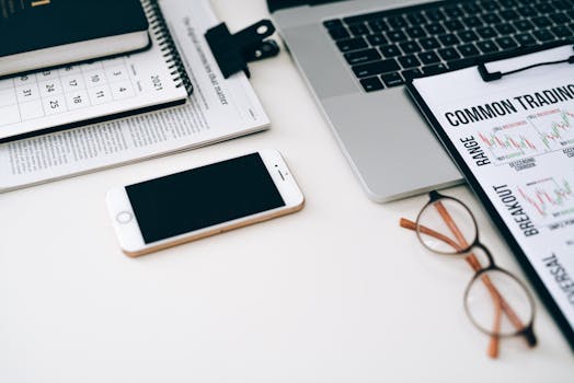 A well-organized office desk setup with finance documents, digital devices, and glasses.