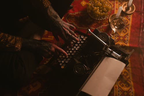 Photo of Person Typing on Vintage Typewriter