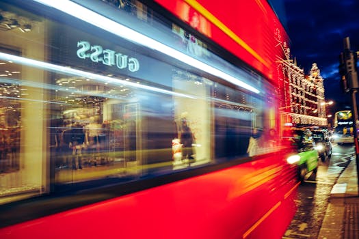 充满活力的城市夜色中，模糊的红色巴士与明亮的路灯展现了城市生活的景象