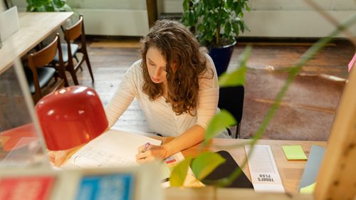Free A woman with brown hair working intently at a desk, indoors in an office environment. Stock Photo