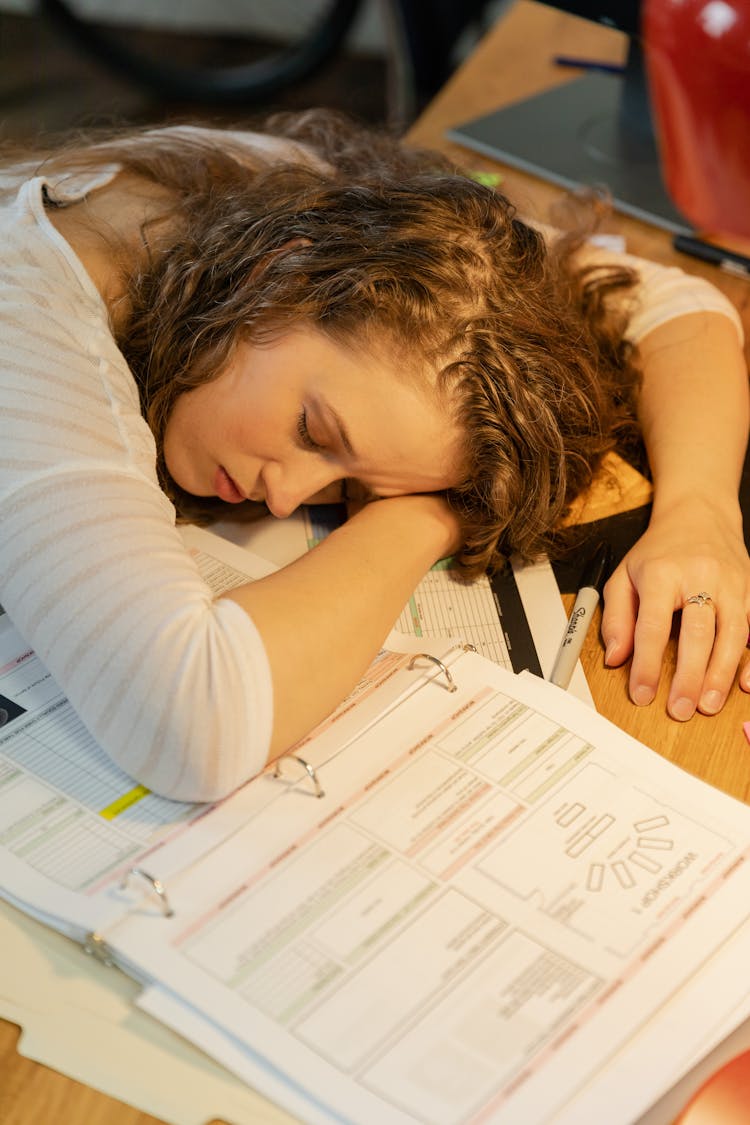 Tired Woman Sleeping On Desk