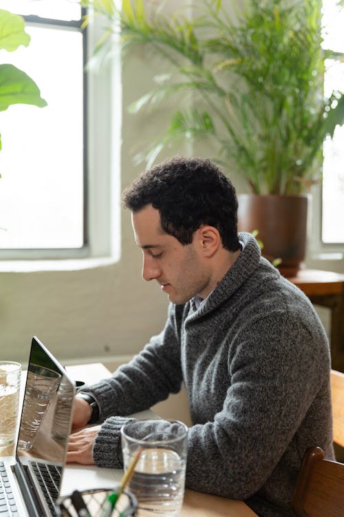 Man in a Gray Sweater Working in an Office