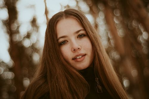 Free Close-up portrait of a young woman with a blurred nature background. Stock Photo